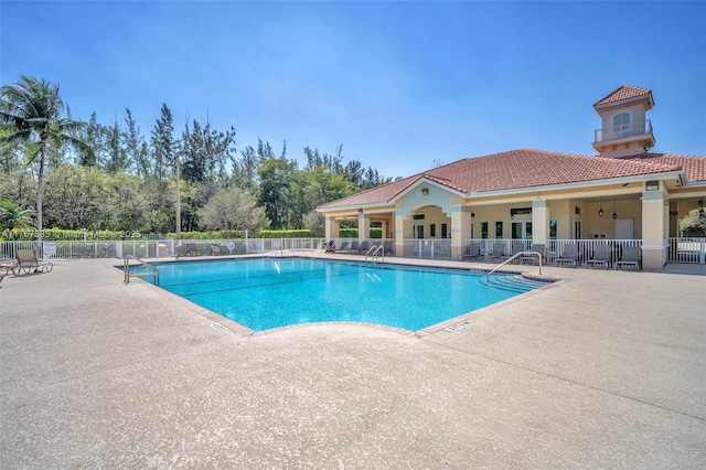 pool with a patio area and fence