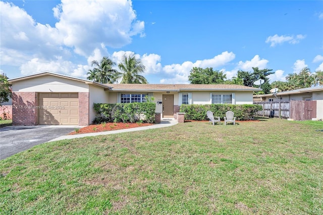 ranch-style home featuring brick siding, a front yard, fence, a garage, and driveway