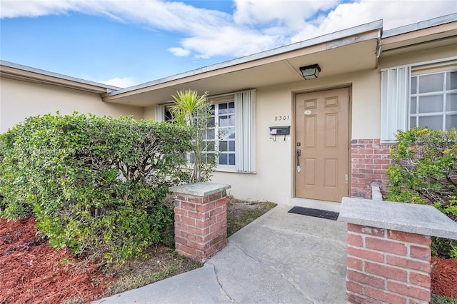 entrance to property featuring stucco siding