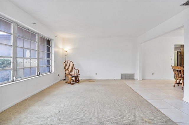 sitting room featuring carpet, tile patterned flooring, visible vents, and baseboards