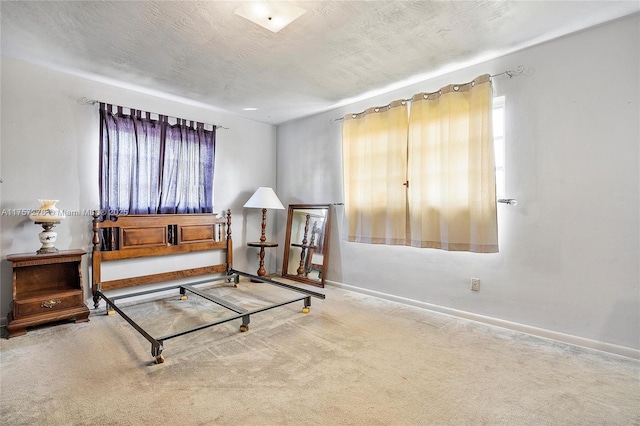 carpeted bedroom with a textured ceiling and baseboards