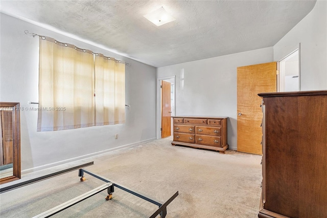 carpeted bedroom with a textured ceiling and baseboards