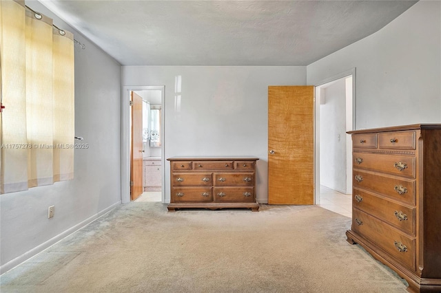 bedroom with light colored carpet and ensuite bath