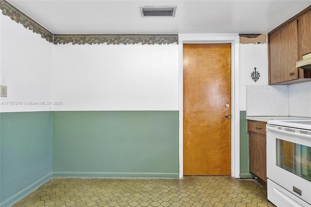 kitchen featuring decorative backsplash, white electric range, visible vents, and baseboards