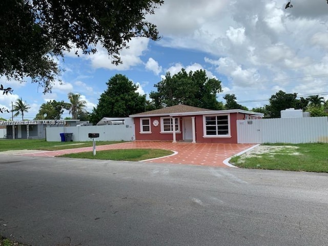 ranch-style house with a front yard and fence