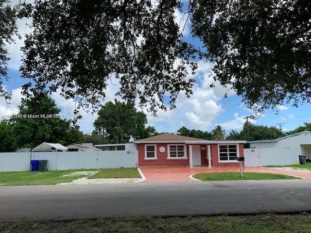 ranch-style house featuring a front yard and fence