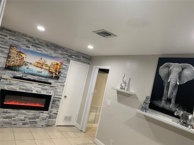 interior space featuring tile patterned flooring, a large fireplace, and visible vents