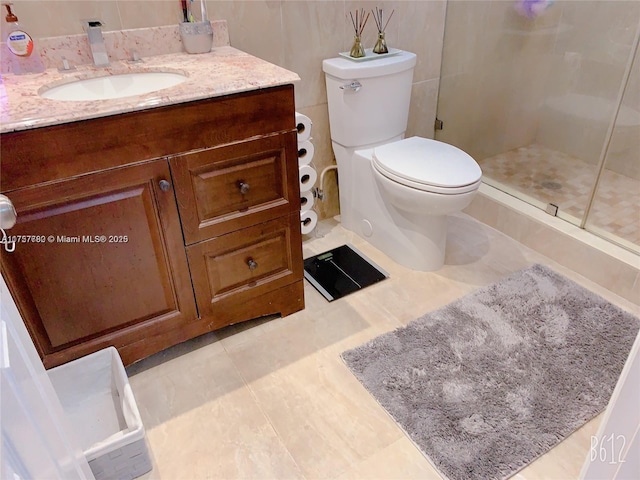 bathroom featuring toilet, a stall shower, tile patterned floors, and vanity