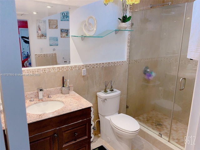 full bathroom featuring a stall shower, tile walls, toilet, and vanity