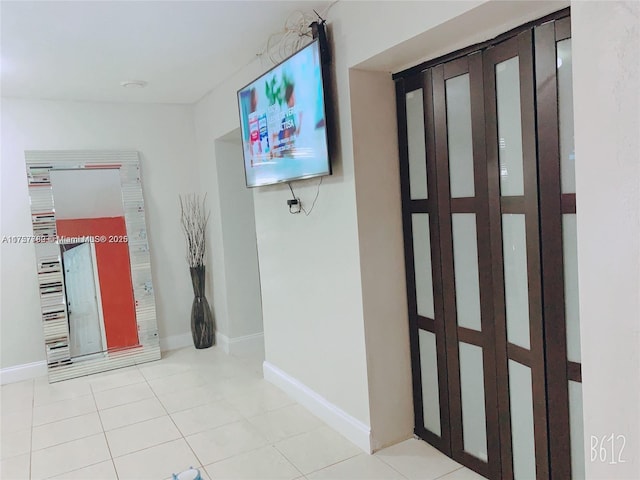 hallway featuring tile patterned flooring and baseboards