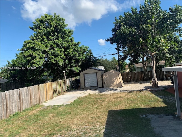 view of yard with an outbuilding, a fenced backyard, and a shed