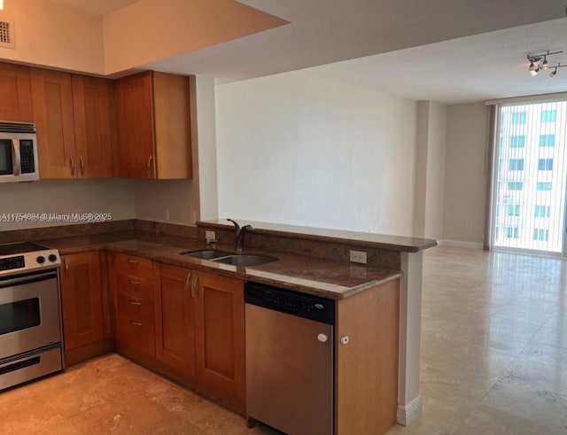 1745 E Hallandale Beach Blvd Unit 804W, Hallandale Beach, FL 33009 - kitchen with appliances with stainless steel finishes, a sink, brown cabinets, a peninsula, and open floor plan