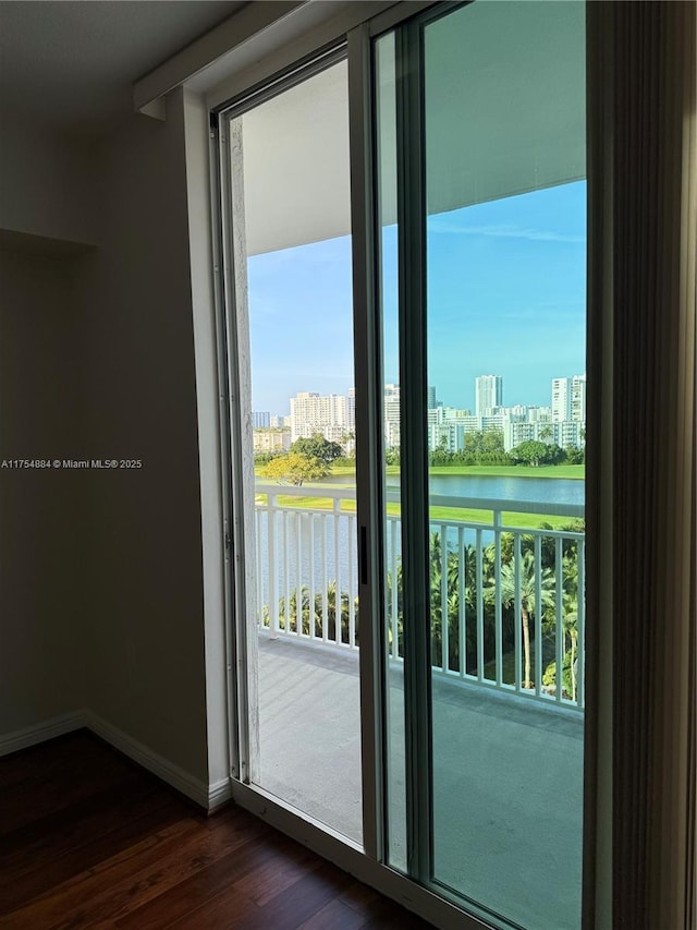 1745 E Hallandale Beach Blvd Unit 804W, Hallandale Beach, FL 33009 - doorway to outside with a city view, dark wood-type flooring, a water view, and baseboards