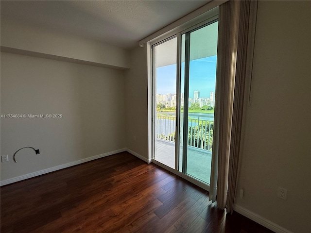1745 E Hallandale Beach Blvd Unit 804W, Hallandale Beach, FL 33009 - unfurnished room featuring dark wood-style flooring, baseboards, and a view of city