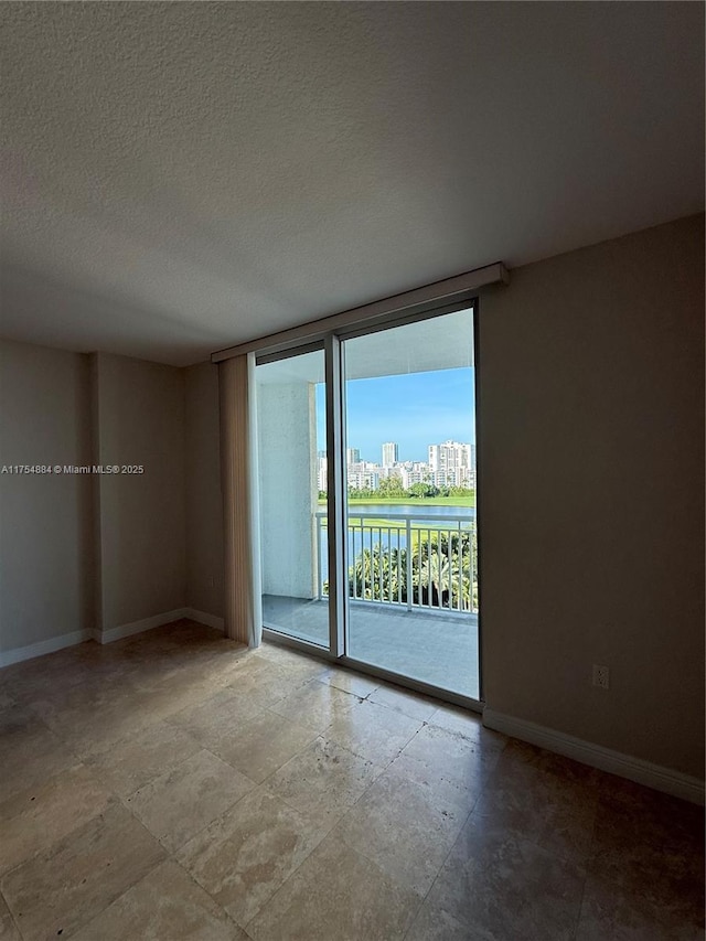 1745 E Hallandale Beach Blvd Unit 804W, Hallandale Beach, FL 33009 - unfurnished room featuring baseboards, expansive windows, and a textured ceiling