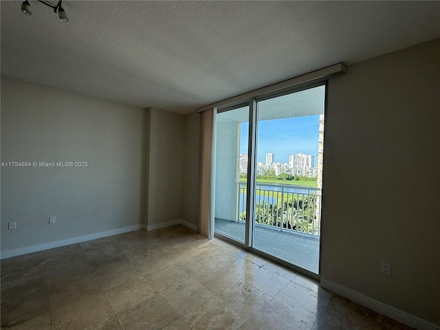 1745 E Hallandale Beach Blvd Unit 804W, Hallandale Beach, FL 33009 - unfurnished room featuring baseboards, a textured ceiling, a view of city, and floor to ceiling windows