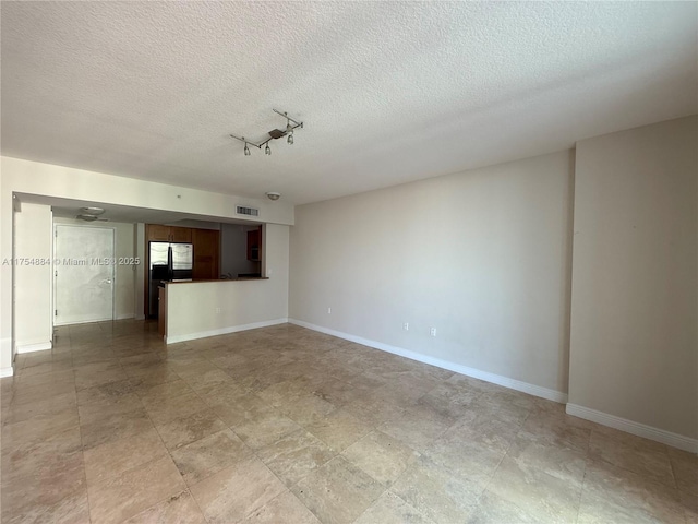 1745 E Hallandale Beach Blvd Unit 804W, Hallandale Beach, FL 33009 - unfurnished living room featuring baseboards and a textured ceiling