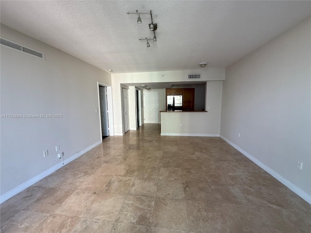 1745 E Hallandale Beach Blvd Unit 804W, Hallandale Beach, FL 33009 - unfurnished living room with baseboards, a textured ceiling, and track lighting