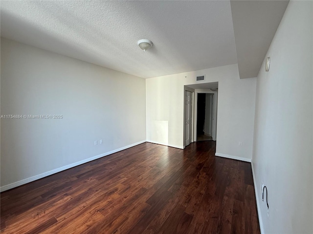 1745 E Hallandale Beach Blvd Unit 804W, Hallandale Beach, FL 33009 - empty room featuring dark wood-style flooring, baseboards, a textured ceiling, and a smoke detector