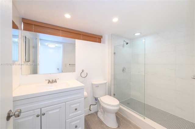 bathroom featuring recessed lighting, tiled shower, vanity, and toilet