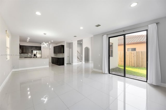 unfurnished living room featuring recessed lighting, visible vents, and baseboards