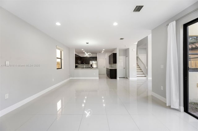 unfurnished living room featuring light tile patterned floors, baseboards, visible vents, and recessed lighting