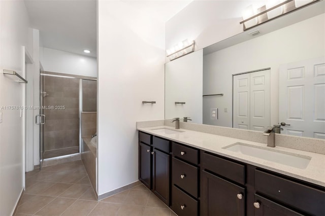 bathroom with double vanity, tile patterned flooring, a sink, and a shower stall