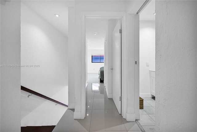 corridor featuring a textured wall and tile patterned flooring