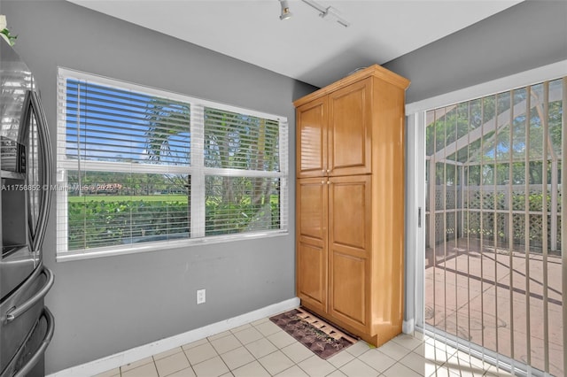 doorway with baseboards and light tile patterned floors