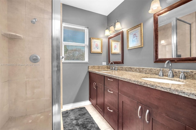 bathroom with double vanity, a shower stall, a sink, and tile patterned floors