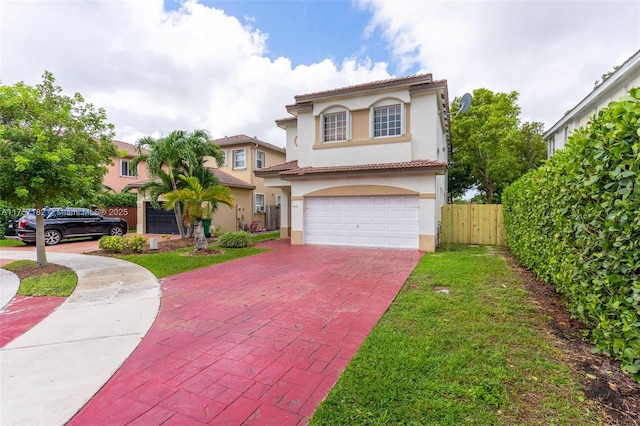 mediterranean / spanish home with decorative driveway, a tile roof, stucco siding, fence, and a garage