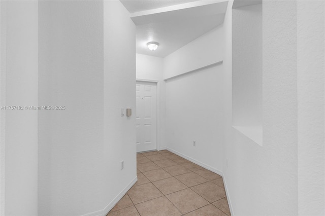 unfurnished room featuring light tile patterned floors and baseboards