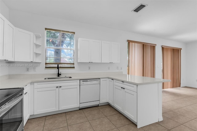 kitchen with visible vents, white cabinets, white dishwasher, a sink, and a peninsula