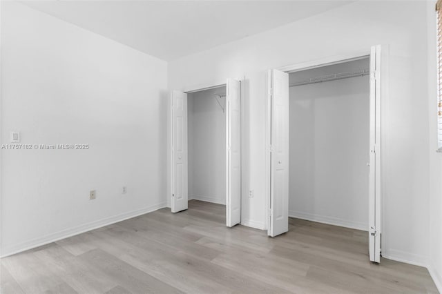 unfurnished bedroom with light wood-type flooring and baseboards