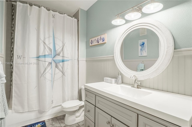 full bath featuring a wainscoted wall, visible vents, toilet, shower / bath combo, and vanity