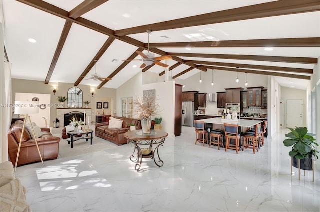 living room featuring ceiling fan, high vaulted ceiling, a lit fireplace, marble finish floor, and beamed ceiling