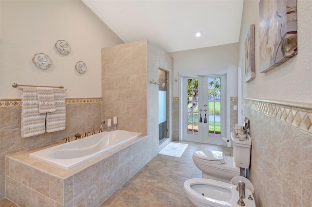 full bathroom with toilet, a garden tub, a shower stall, a bidet, and tile walls