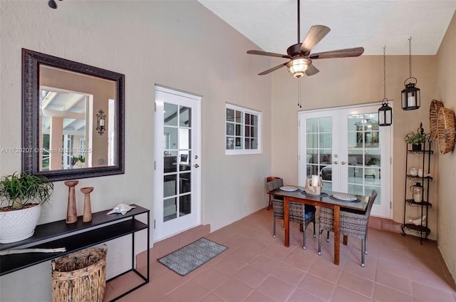 tiled dining area with lofted ceiling, french doors, and a ceiling fan