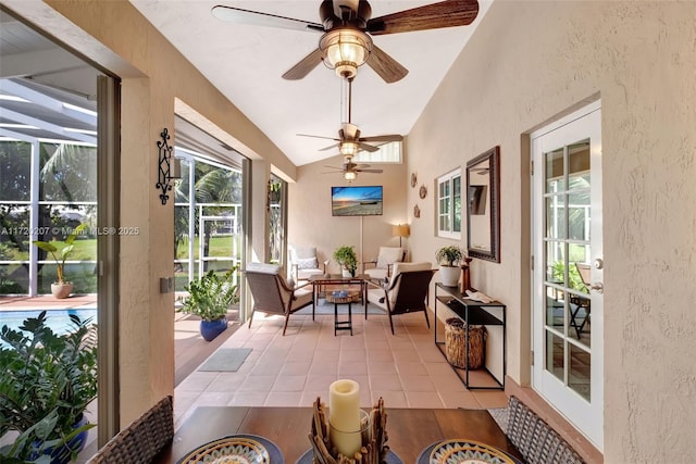 sunroom / solarium featuring lofted ceiling, a ceiling fan, and a wealth of natural light