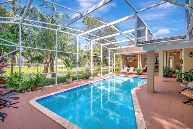 pool featuring a lanai, a patio area, and a ceiling fan