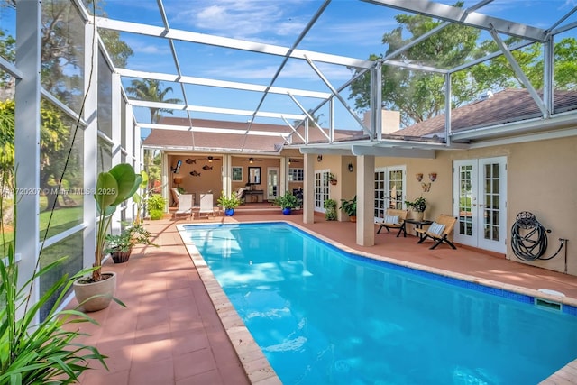 outdoor pool featuring a patio, french doors, glass enclosure, and a ceiling fan