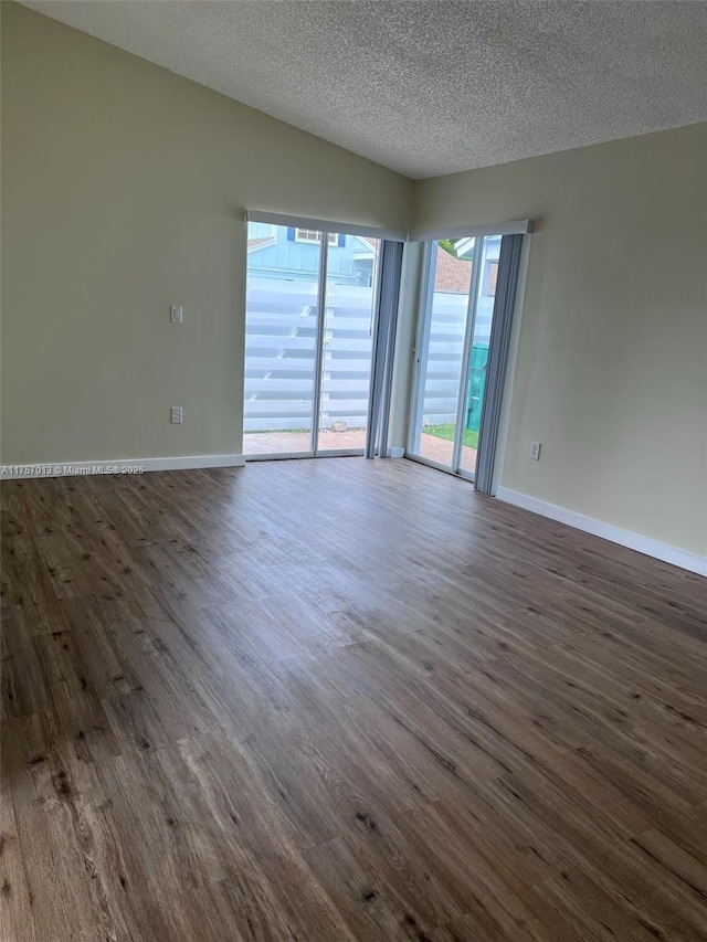 spare room with dark wood-style floors, baseboards, and a textured ceiling