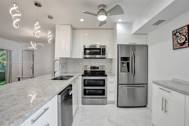 kitchen with white cabinets, decorative backsplash, marble finish floor, stainless steel appliances, and a sink