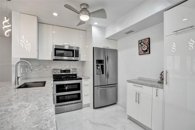 kitchen with visible vents, marble finish floor, stainless steel appliances, white cabinetry, and a sink