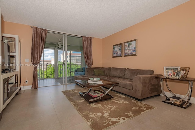 living area featuring a textured ceiling, tile patterned flooring, and baseboards