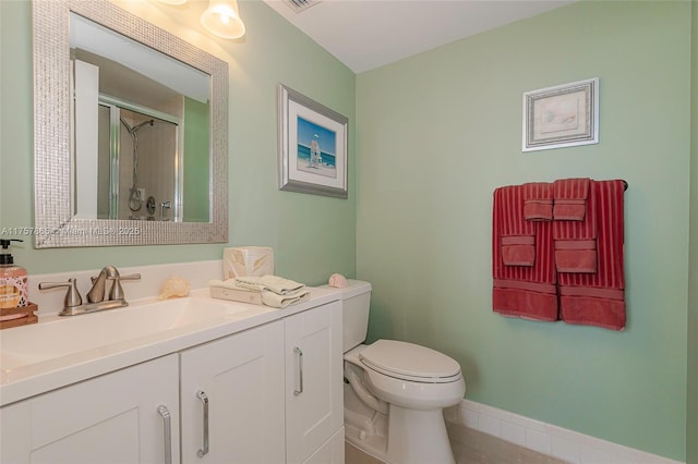 full bathroom with toilet, a shower stall, vanity, baseboards, and tile patterned floors