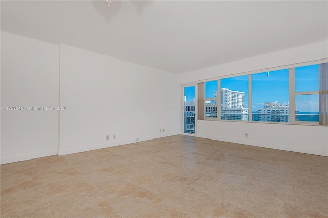 spare room with a city view and baseboards