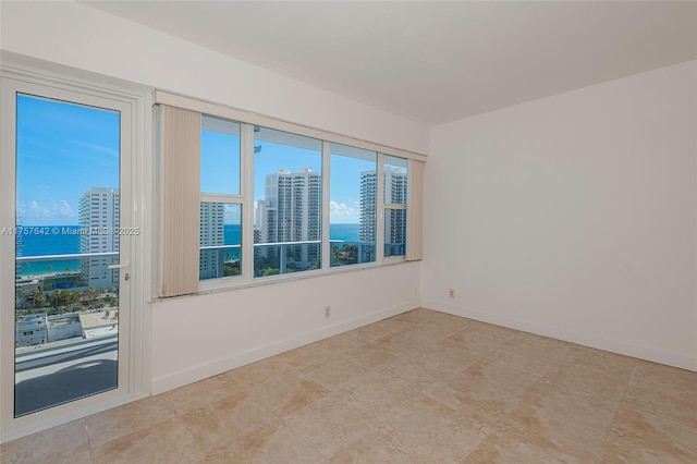 spare room featuring baseboards and a city view