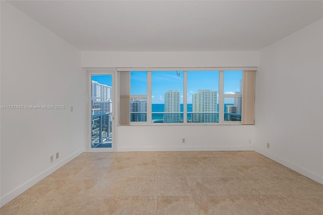 empty room with baseboards and a city view