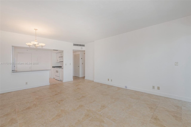 spare room with visible vents, a notable chandelier, and baseboards